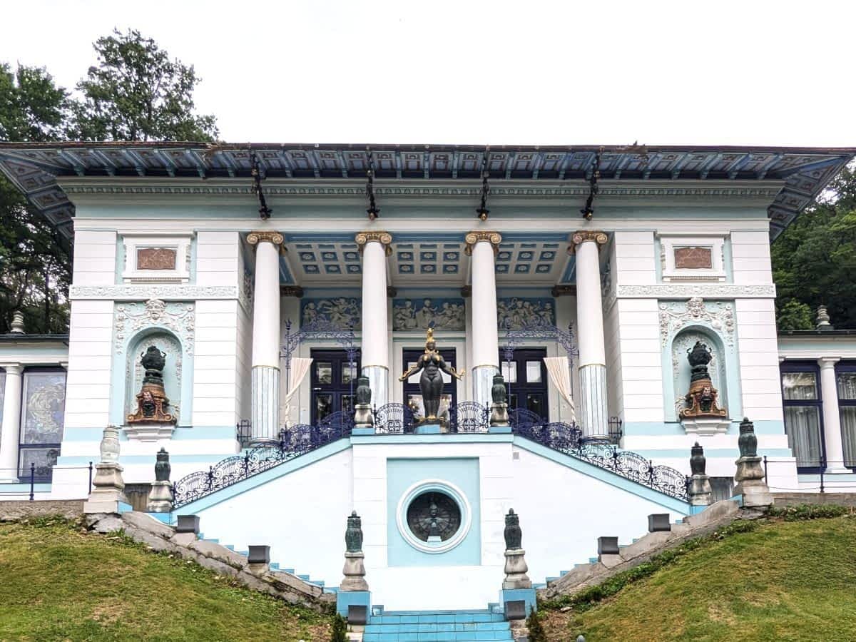 Die prachtvolle Otto-Wagner-Villa in Wien mit klassischen Säulen und einer zentralen Skulptur auf der Treppenanlage.